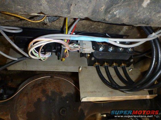 Air suspension manifold with wires and hoses attached to a vehicle's undercarriage