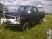 1979 Ford Bronco - This Ford Bronco is parked in a grassy field next to a building and a swing set.