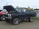 1979 Ford Bronco - A dark blue 1979 Ford Bronco is parked with its hood open, revealing the engine compartment.