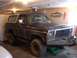 1979 Ford Bronco - This 1979 Ford Bronco is parked in a garage, showing its distinctive body style and dark paint with a white top.