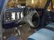 1979 Ford Bronco - The interior of a 1979 Ford Bronco features blue upholstery and a dashboard with aftermarket gauges.