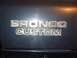 1979 Ford Bronco - Close-up of a Bronco Custom emblem, likely from a Ford Bronco.