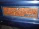 1979 Ford Bronco - Close-up of a blue vehicle's rear panel, woodgrain trim and a "CUSTOM" badge.