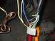 1979 Ford Bronco - A close-up view of a vehicle's electrical wiring harness, showing various colored wires and a connector.