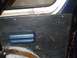 1979 Ford Bronco - Close-up of an interior door panel showing a blue armrest and wood grain texture.