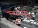 1979 Ford Bronco - Close-up of an engine bay with prominent red spark plug wires and battery.