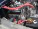 1979 Ford Bronco - The engine bay shows a battery with corroded terminals and various hoses and wires connected to the engine block.