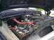 1979 Ford Bronco - The engine bay of a dark blue vehicle is shown with various components and wiring visible.