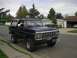 1979 Ford Bronco - This 1979 Ford Bronco, seen from a three-quarter front view, is parked on a residential street with a white top and off-road tires.