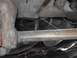 1979 Ford Bronco - The underside of a vehicle reveals suspension components and exhaust system parts, with visible signs of wear and tear.