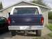 1979 Ford Bronco - Rear view of a dark blue 1978 Ford Bronco with a white hardtop, parked in front of a garage.