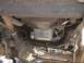 1979 Ford Bronco - The underside of a vehicle reveals its mechanical components, including the drivetrain and suspension.