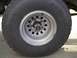 1979 Ford Bronco - Close-up of a Yokohama Geolandar tire and silver rim with a chrome hub.