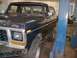 1979 Ford Bronco - A dark blue and white 1979 Ford Bronco is shown in a garage, possibly undergoing maintenance.