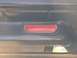 1979 Ford Bronco - Interior shot of a vehicle's door panel, a red reflector and a chrome pull handle.