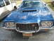 1972 Ford Ranchero - Front view of a blue 1972 Ford Ranchero with a hood scoop, parked next to a pickup truck.