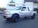 2010 Ford Ranger - A silver Ford Ranger pickup truck is parked in front of a building with large windows.