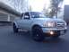 2010 Ford Ranger - Silver pickup truck with black wheels parked in front of a modern building.