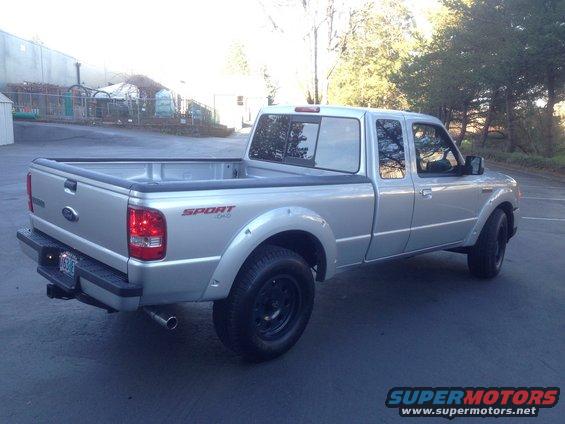 Silver pickup truck, rear quarter view. Has 'SPORT 4x4' decal on fender