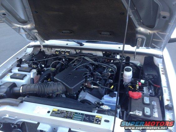 Silver Ford Ranger engine bay with hood open. Visible components include the engine, battery, air intake, and various hoses and wires