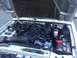 2010 Ford Ranger - The engine bay of a silver Ford Ranger shows its internal components under the open hood.