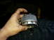 1981 Ford Bronco - A mechanic holds a Warn Hub part, likely for a 4x4 vehicle, in front of a tire.