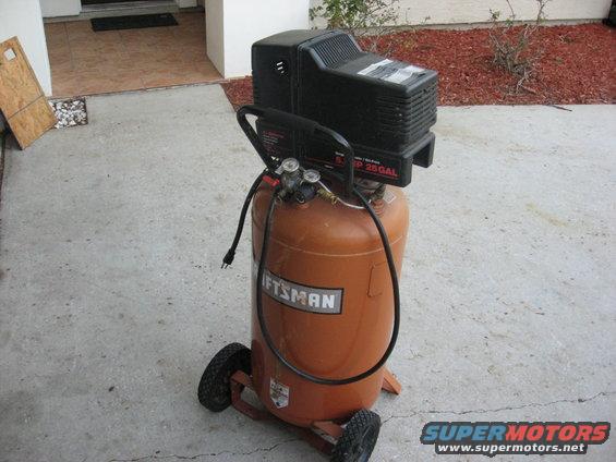 Orange Craftsman air compressor with black top, on wheels, with visible gauges and hoses