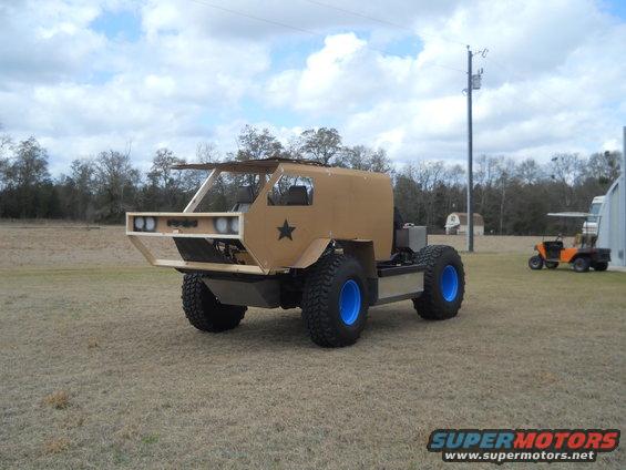 Custom tan off-road vehicle with blue wheels and a star emblem