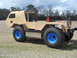 1992 Ford Bronco - This custom-built vehicle features large off-road tires with striking blue rims and an unfinished wooden body, suggesting a project in prog…