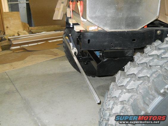Vehicle frame and large tire with metal bar clamped to it