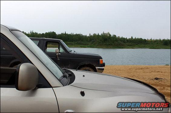 Side view of a black 1987 Ford Bronco parked by a lake