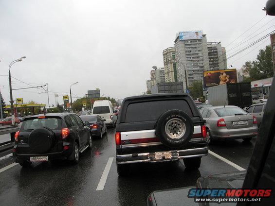 1987 Ford Bronco rear view in traffic, spare tire mounted on back