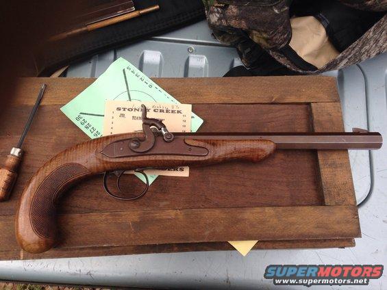Flintlock pistol with wooden stock and metal components on a wooden surface