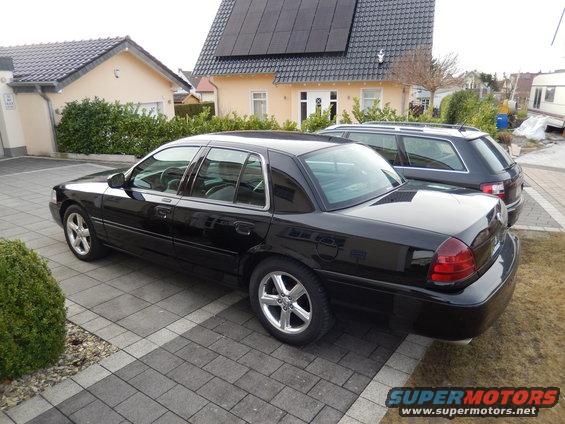 black 2003 Mercury Marauder parked on driveway, another car and houses in background