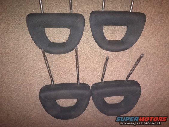 Four black car headrests with metal posts