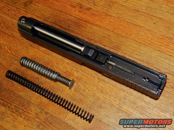 Gun slide and two springs on wooden surface. Supermotors.net logo visible