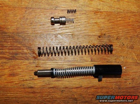gun parts and springs laid out on wood