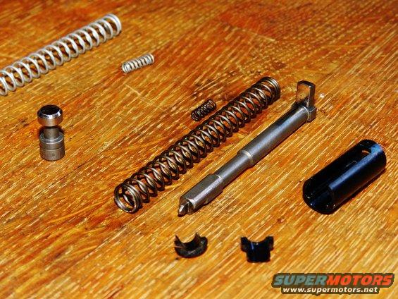 Metal springs and mechanical parts laid out on a wooden surface