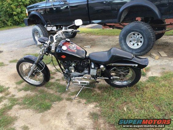 1973 Harley-Davidson XLCH Sportster parked next to a lifted black pickup truck