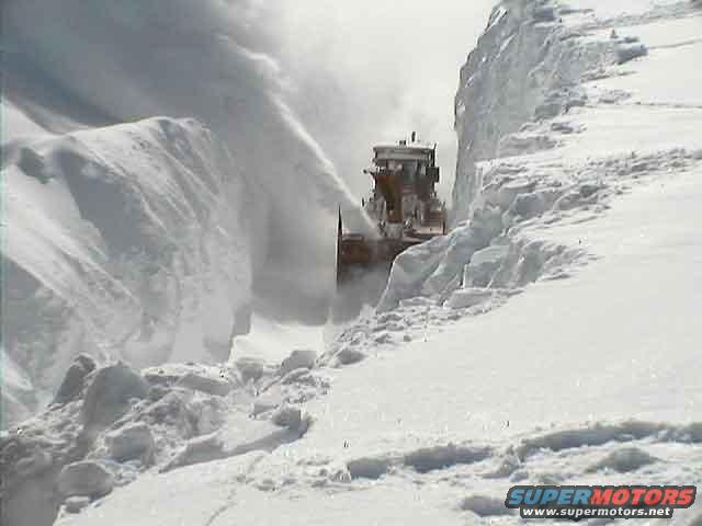 Snow blower clearing a path through deep snowdrifts