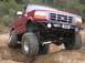 1996 Ford Bronco - Modified 1996 Ford Bronco navigating an off-road obstacle with its front wheels elevated.