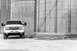 2006 Chevrolet Silverado 2500 - A white pickup truck is parked in front of large, industrial silos.