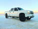 2006 Chevrolet Silverado 2500 - A white 2006 Chevrolet Silverado 2500 pickup truck sits on a snowy plain under a clear sky.