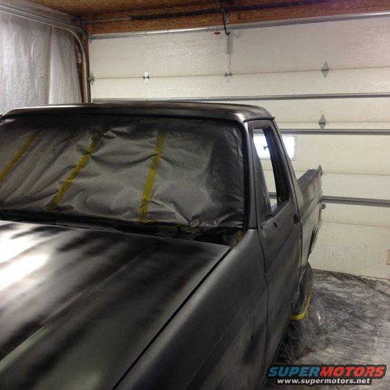 Gray truck cab with masked windshield, side view of door and bed