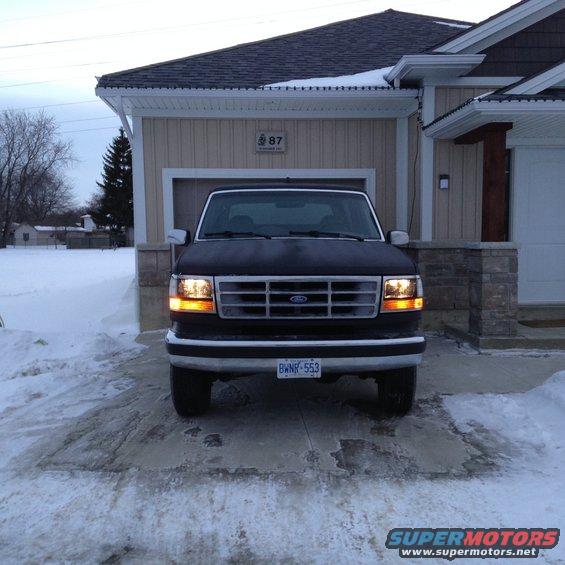1992 Ford Bronco parked in front of a garage in the snow