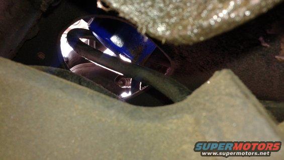 Close-up of a blue shock absorber and hose assembly under a vehicle