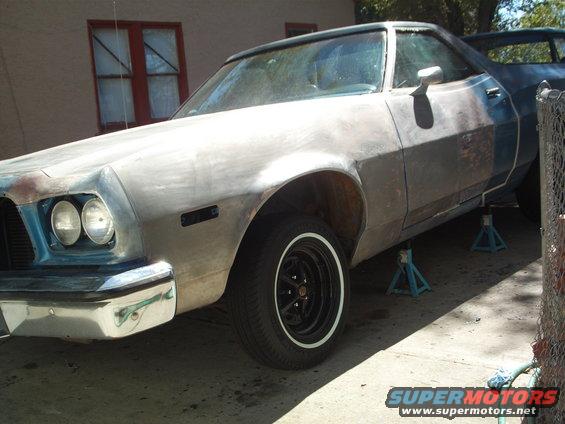 Unpainted 1972 Ford Ranchero on jack stands, front 3/4 view