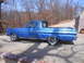 1965 Ford Ranchero - A blue 1965 Ford Ranchero pickup truck is parked on a concrete driveway with trees in the background.
