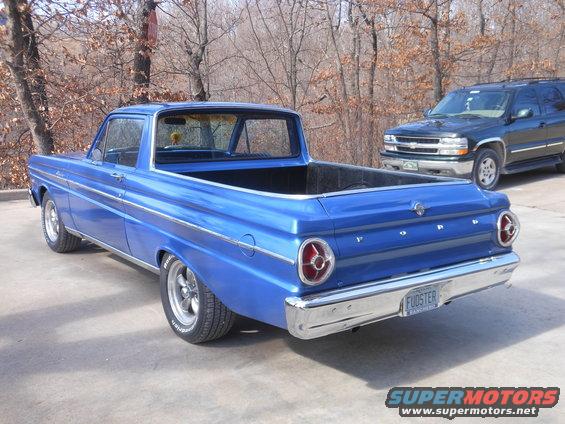 Blue 1965 Ford Ranchero pickup truck parked outside, with a dark SUV behind it