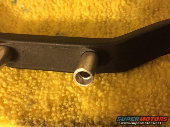 Black metal bracket with two silver posts on a yellow textured surface. Text reads SUPERMOTORS